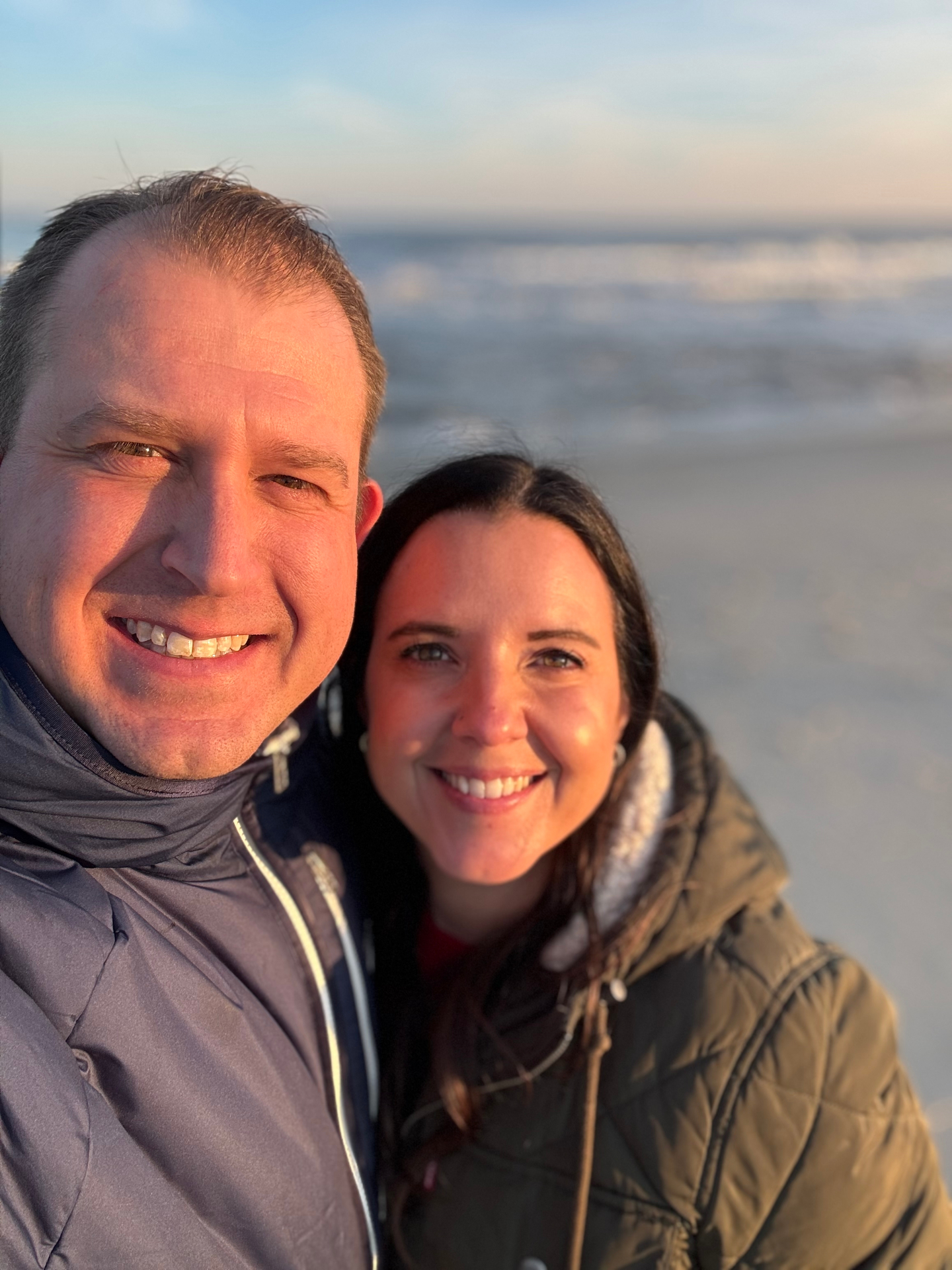 Matt and his wife at the beach during sunset.